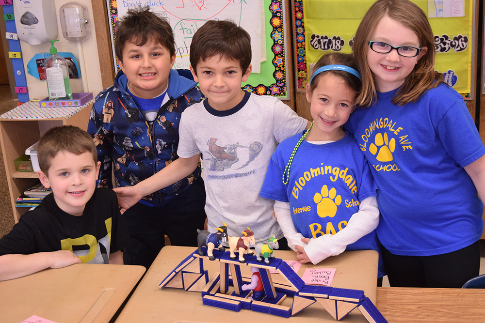 Students standing next to their Lego creation.