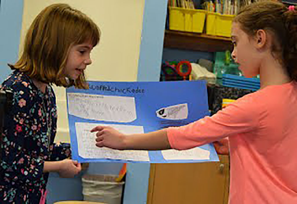 Two students reading a poster about nature